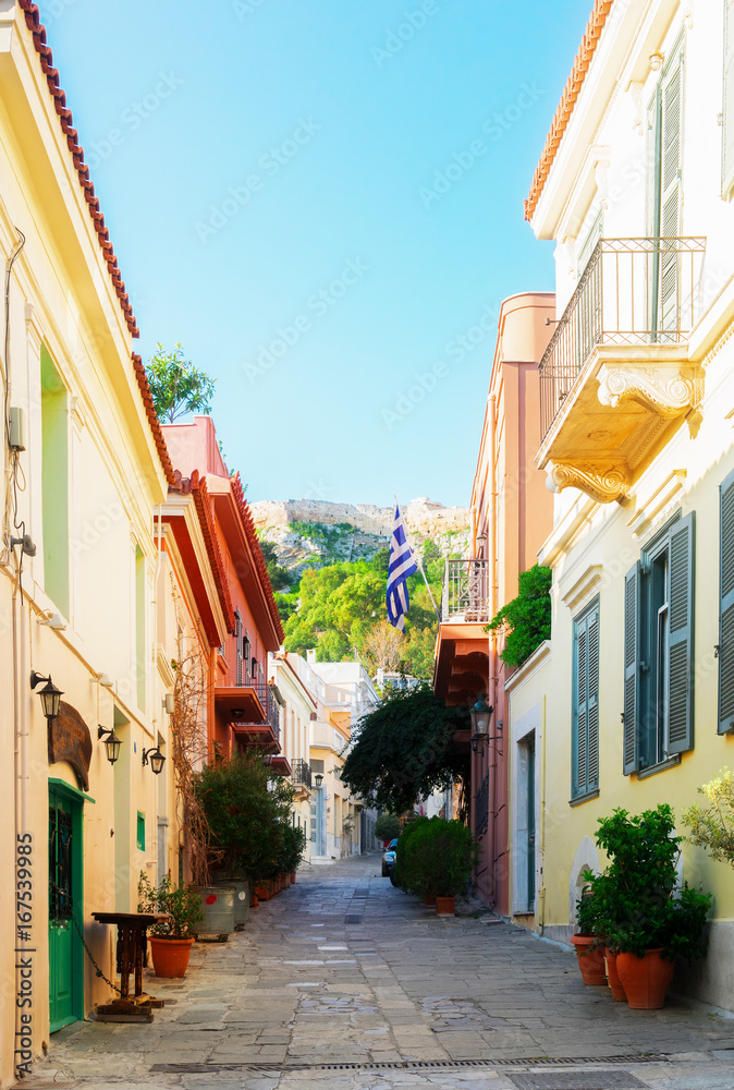 Fototapeta premium small cosy street of Placa district with Acropolis hill in Athens, Greece, retro toned