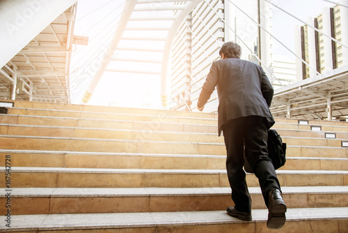 Businessman walking the stairs with city background, Businessmen go to success concept.