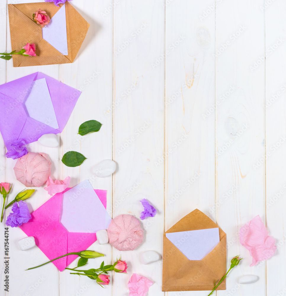 Envelope, paper blank and pink rose flower on white table top view in flat lay style for greeting card on Womans day.