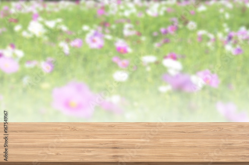 Wood table and blurry flower garden background. Empty table for display or montage your products. © Forrest9