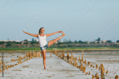 Pretty woman doing yoga on the ground outdoors © ViDi Studio