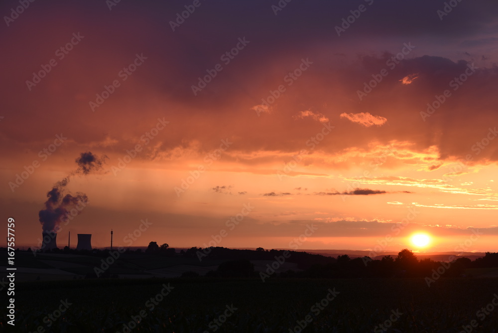 Sonnenuntergang mit kräftigenund intensiven Abendrot mit Kernkraftwerk im Hintergrund