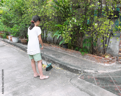 Cleaning. Broom. This girl was sweeping the street in front of her house. It is easy for children to help with the housework. © BK_graphic