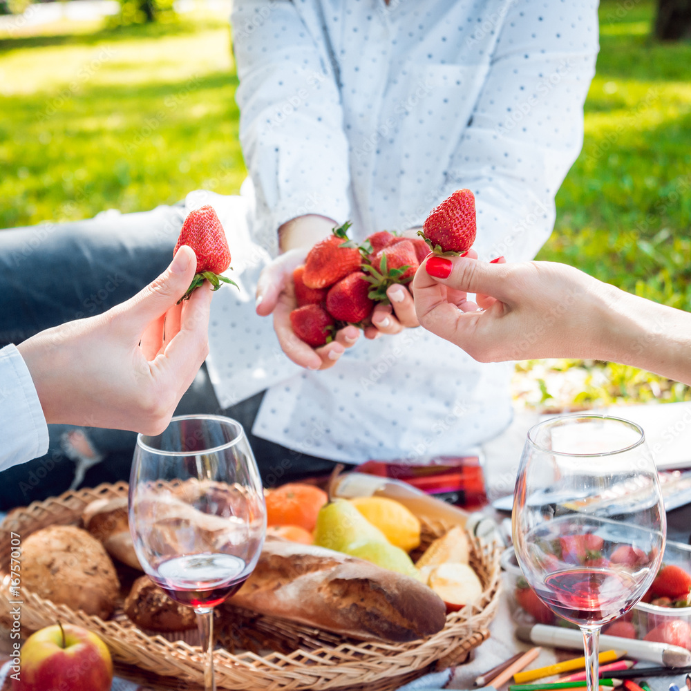 Young beautiful girls eating strawberries in the park Young beautiful girls eating strawberries in the park