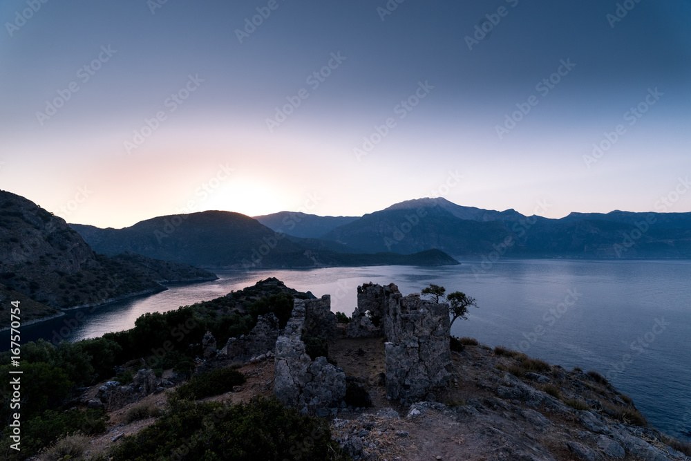 Sunrise over sea and mountains. Rocks and sea scenery Sunrise over sea and mountains. Rocks and sea scenery