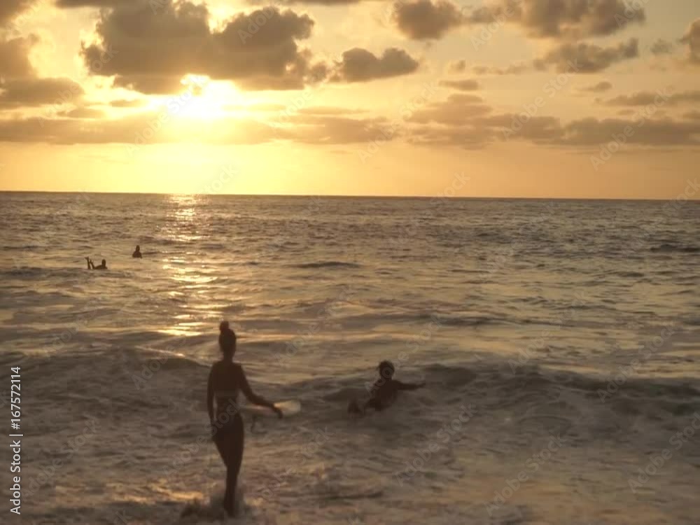 Young couple surfing at sunset