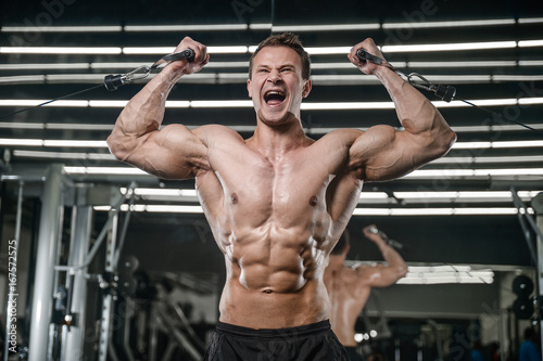 Caucasian handsome fitness model training in the gym. Man on diet flexing muscles © antondotsenko