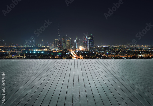 Wooden terrace with skyline of Dubai at night