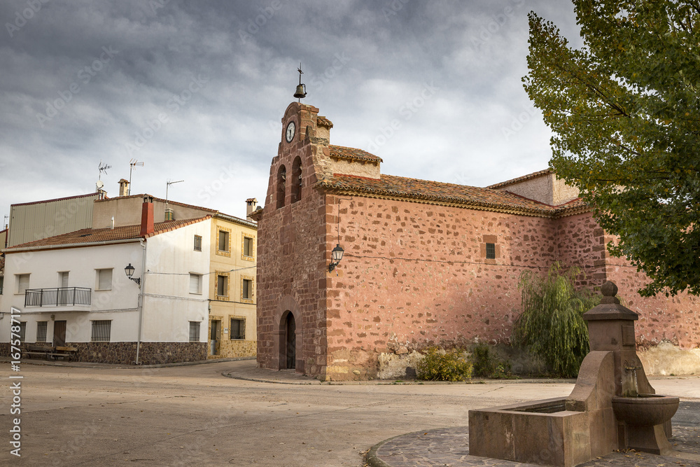 a street and San Juan Bautista parish church in Chequilla village, Province of Guadalajara, Spain