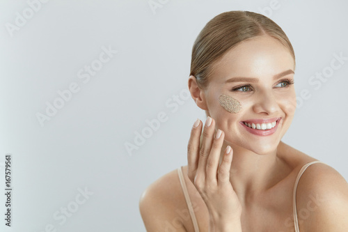 Face Skin Scrub. Smiling Female Applying Scrub On Face Skin photo