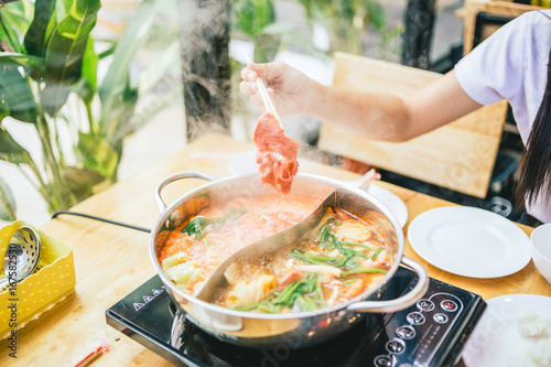 chopsticks take beef slice into shabu shabu pot, healthy food