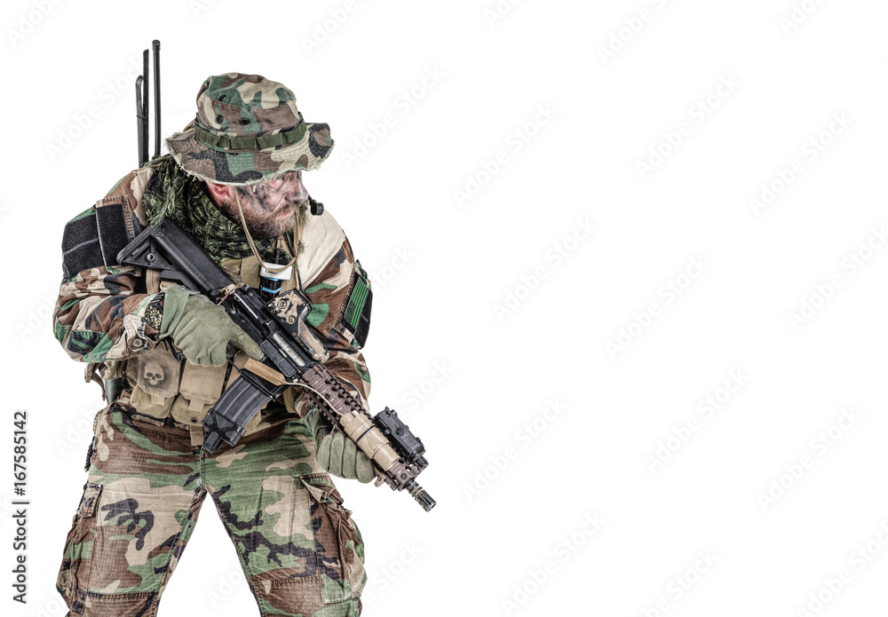 Fototapeta premium Special forces United States in Camouflage Uniforms studio shot. Holding weapons, wearing jungle hat, Shemagh scarf, painted face, his outfit clothes designed for jungle warfare. Studio shot isolated