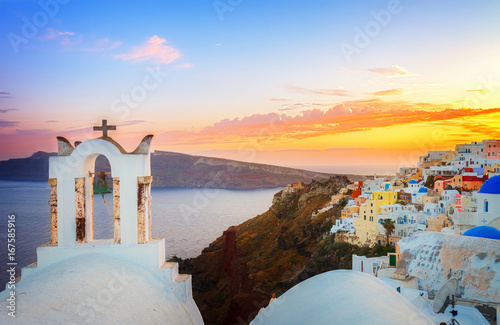 cityscape of Oia, traditional greek village of Santorini, with white bellfry at sunset, Greece, retro toned