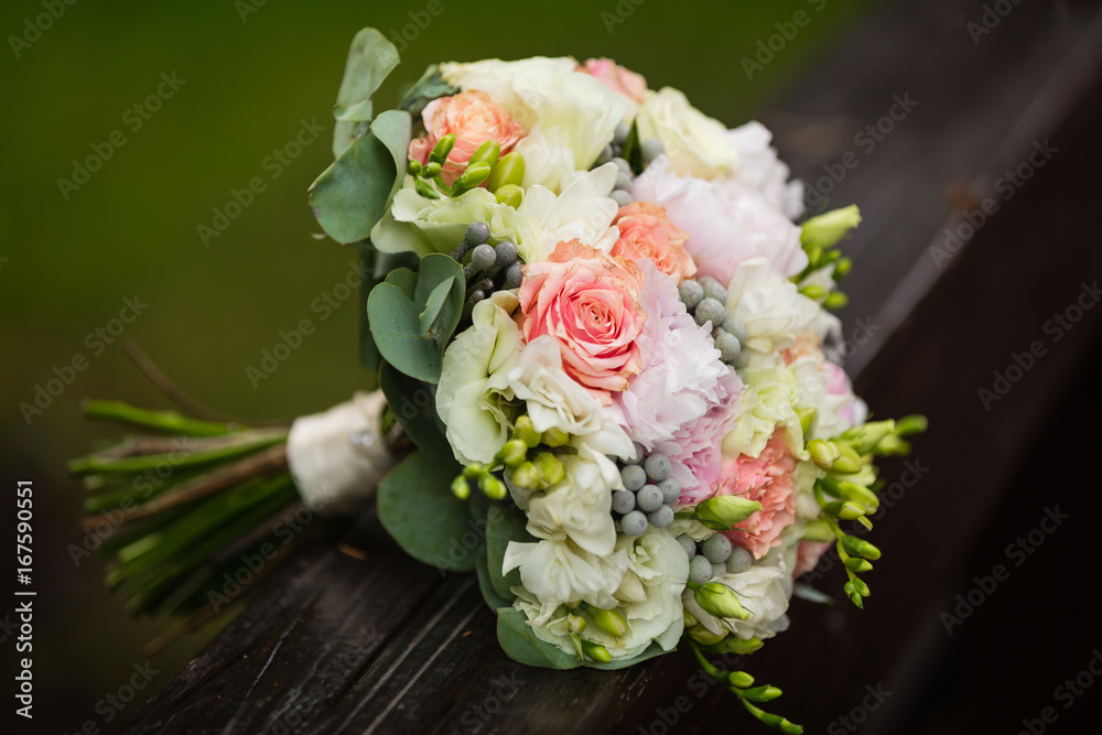 luxurious bridal bouquet of white peonies and roses near the tree