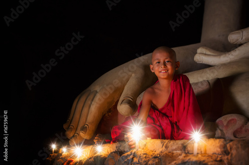 Fototapeta Naklejka Na Ścianę i Meble -  A boy in buddhism set fire with candle in bagan