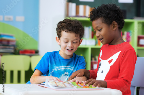 Photo Student in international preschool reading a magazine book together