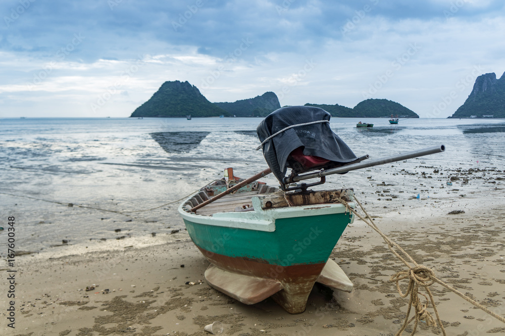 alone Fishing boat on the beach cloudy background