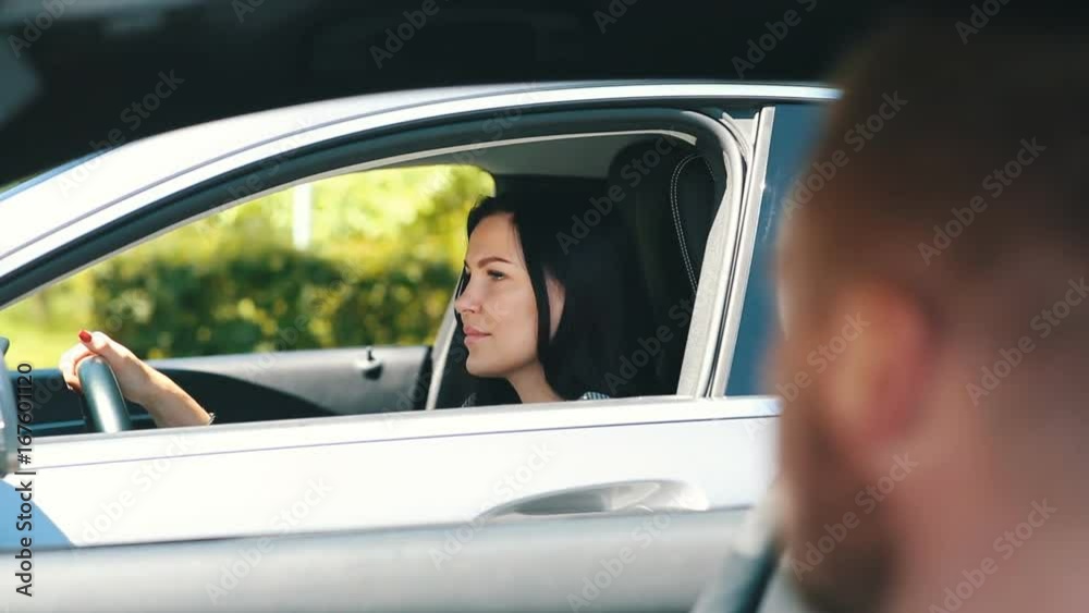 young brunette in the car talking with a man from the neighboring car young brunette in the car talking with a man from the neighboring car
