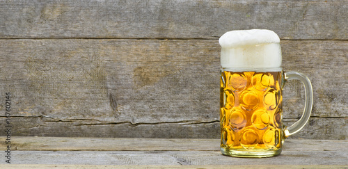 Maßkrug Bier steht auf Holztisch beim Oktoberfest in München, Bayern Fototapet