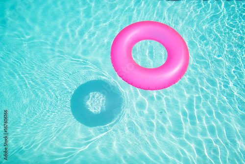 Canvas-taulu Bright pink float in blue swimming pool, ring floating in a refreshing blue swimming pool with waves reflecting in the summer sun