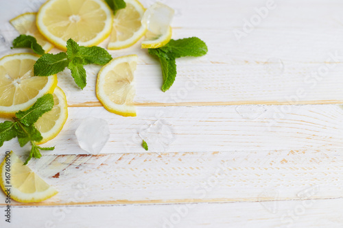 Lemon with ice on white wooden background