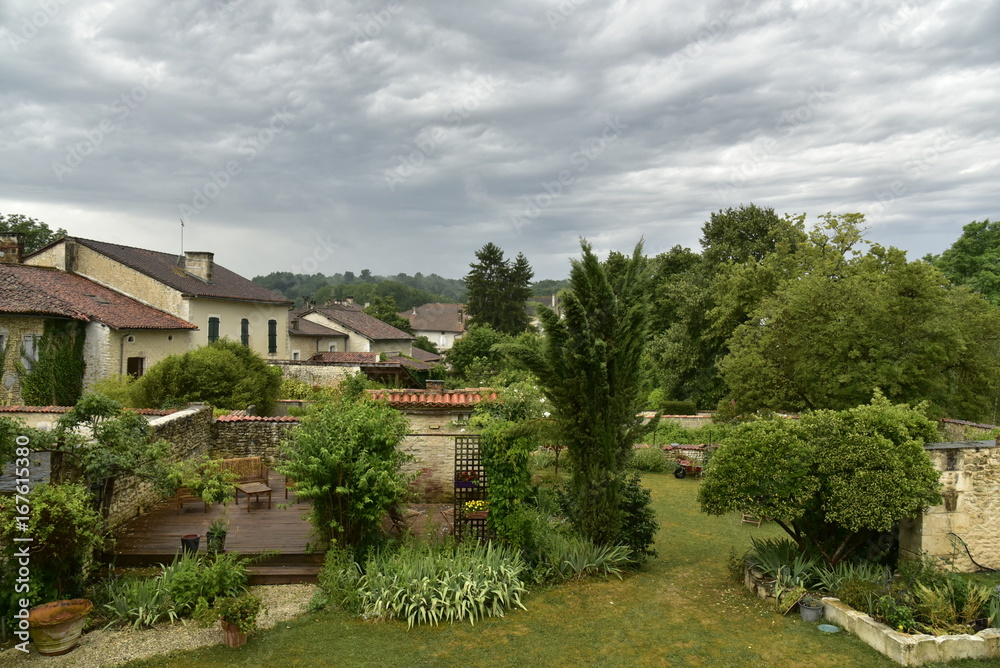 Passage d'un front orageux au dessus des jardins et des maisons rustiques au village de Champagne, au Périgord Vert 