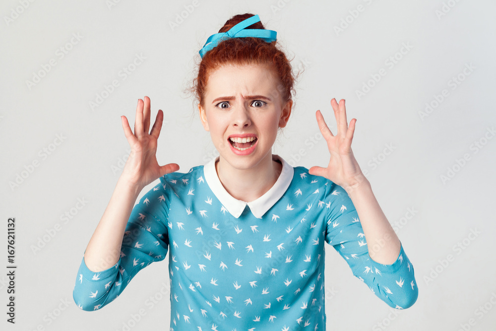 girl in despair and shock. Portrait of young angry redhead girl in blue ...