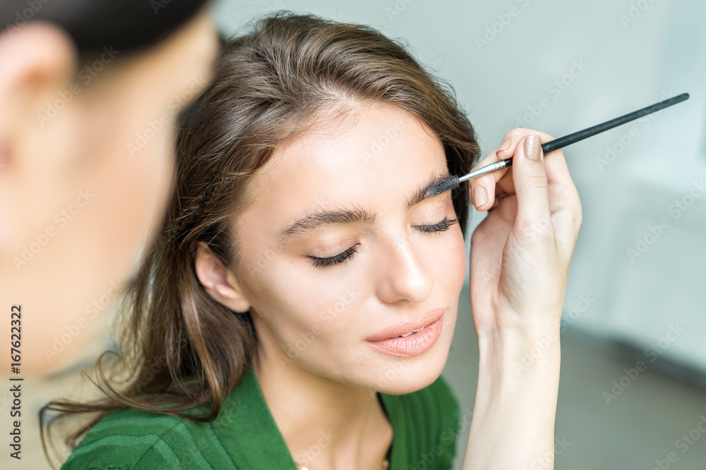 Woman paints the eyebrows