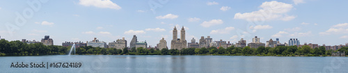 Central Park West skyline and the Jacqueline Kennedy Reservoir in New York City with apartment skyscrapers over lake with fountain in midtown Manhattan and lake reflection 