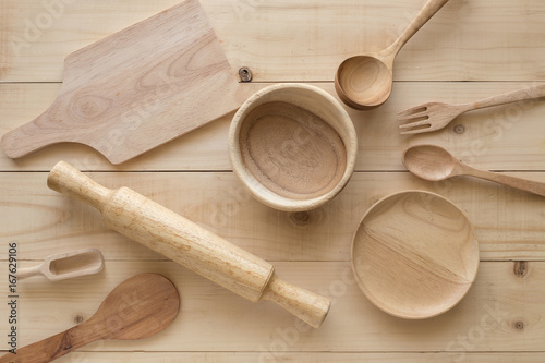 wooden rolling pin and Various wooden cooking utensils on brown table