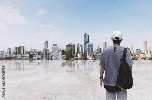 a man with backpack standing at sightseeing city view in the morning