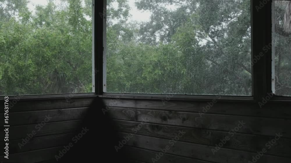 rain falling outside a screened in patio during a thunderstorm