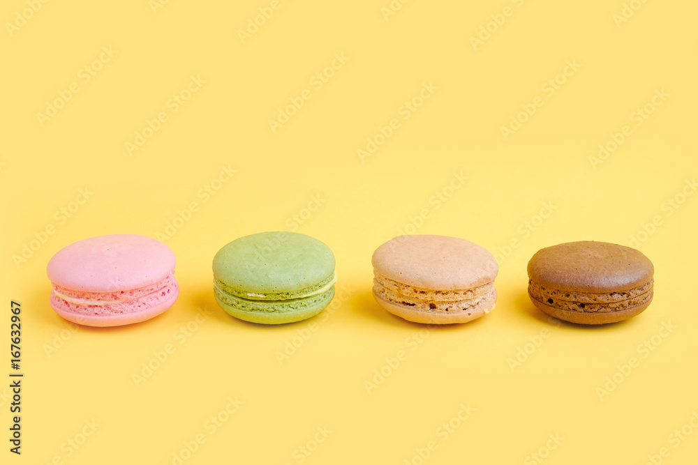 Varieties french macaroons biscuit with yellow background Varieties french macaroons biscuit with yellow background