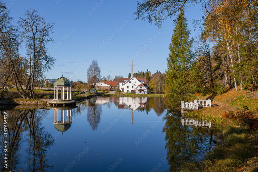 Rich old estate with a pond, rotunda and decorative pier. Palmse, Estonia. Autumn sunny day.