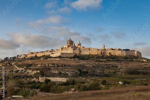 Ancient hilltop fortified by old capital city of Malta, The Silent City, Mdina or Rabat, skyline at sunrise.