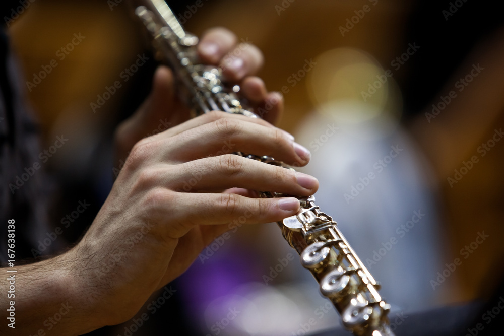 Fototapeta premium Detail of a musician flute in his hands closeup in dark colors