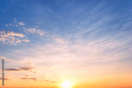 Sky background at sunset,Sky blue and orange light of the sun through the clouds in the sky © Sky Stock