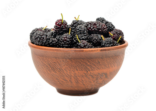 Ceramic bowl filled with black mulberries isolated on white background