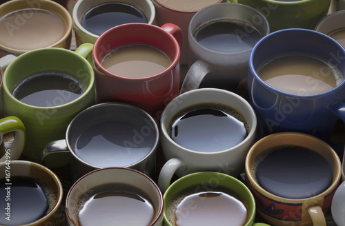 coffee time - lots of coffee in different cups on wooden table good background for text or graphic design. coffee lover - lots of coffee cup in different cups.
