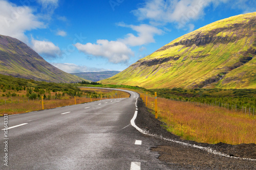 Beautiful icelandic deserted roadway among green hills. Copy space.