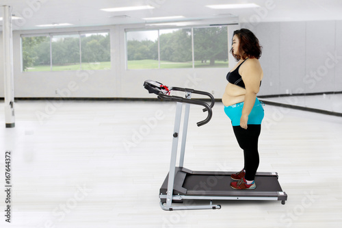 Fat woman exercising with a treadmill