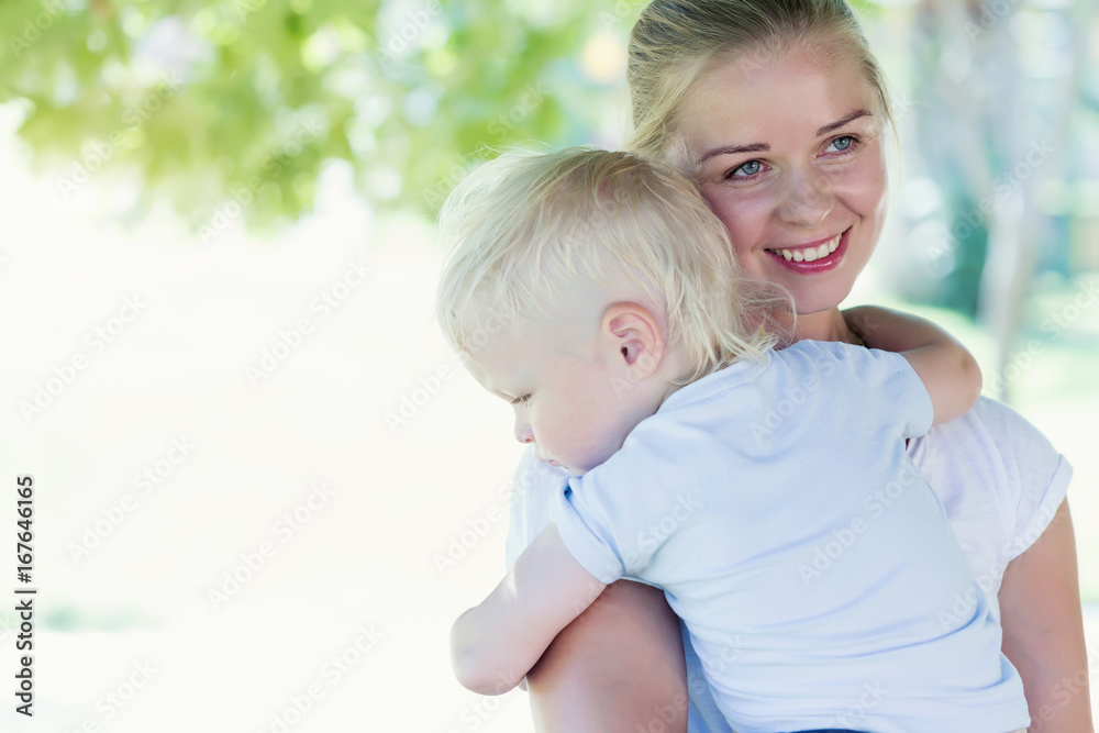 Mother hugging a crying boy in summer park Mother hugging a crying boy in summer park