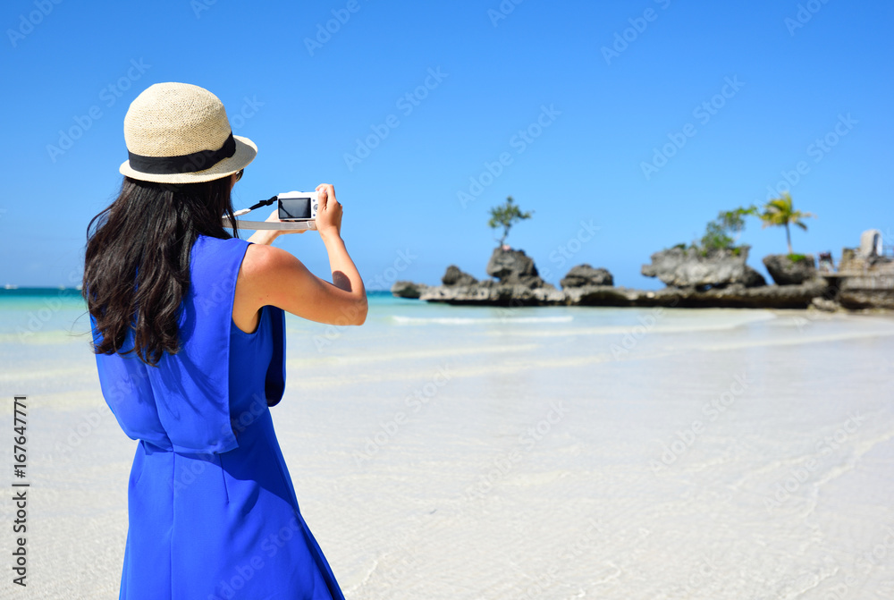Young asian woman take picture using smartphone at beach