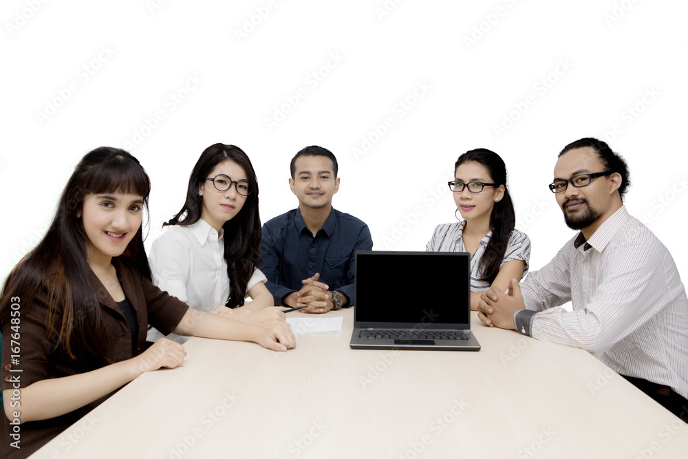 Multiracial employees with laptop on table Multiracial employees with laptop on table