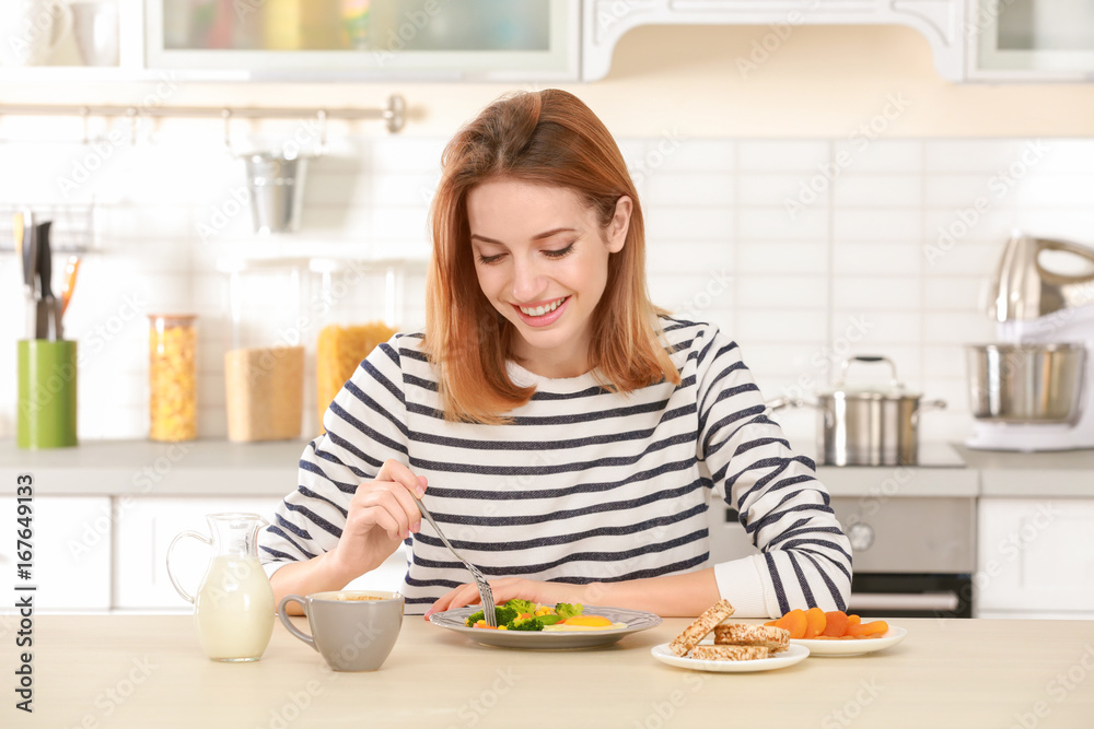 Young pretty woman having delicious breakfast in light kitchen Young pretty woman having delicious breakfast in light kitchen