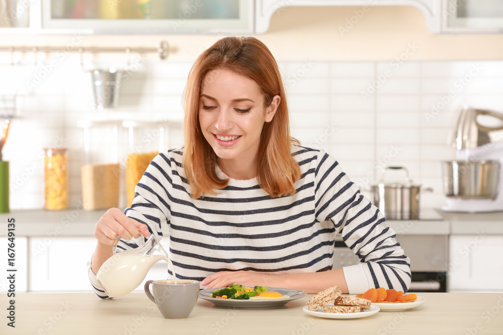 Young pretty woman having delicious breakfast in light kitchen Young pretty woman having delicious breakfast in light kitchen