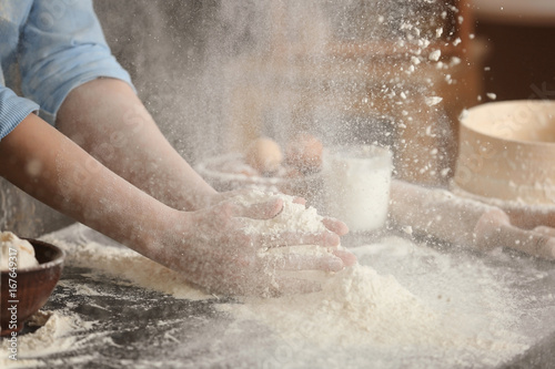 Female chef with flour on table in kitchen