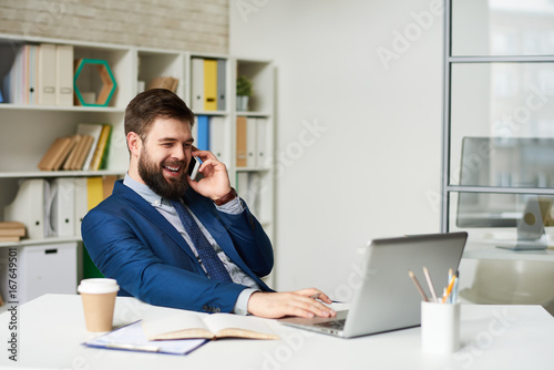 Successful Businessman Speaking by Phone in Office