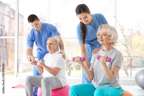 Fototapeta Naklejka Na Ścianę i Meble -  Physiotherapists working with elderly patients in modern clinic