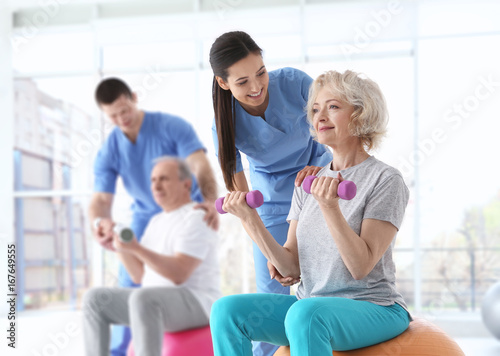 Physiotherapists working with elderly patients in modern clinic photo